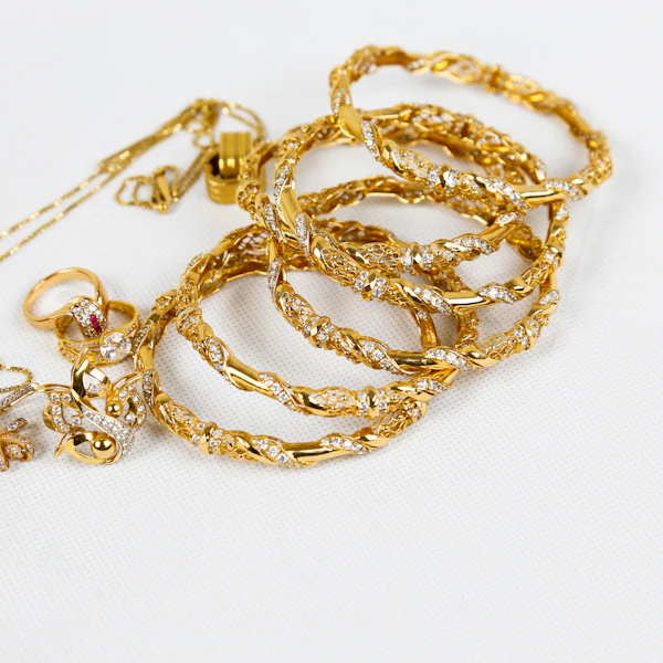 Gold chains and bracelets on a white surface