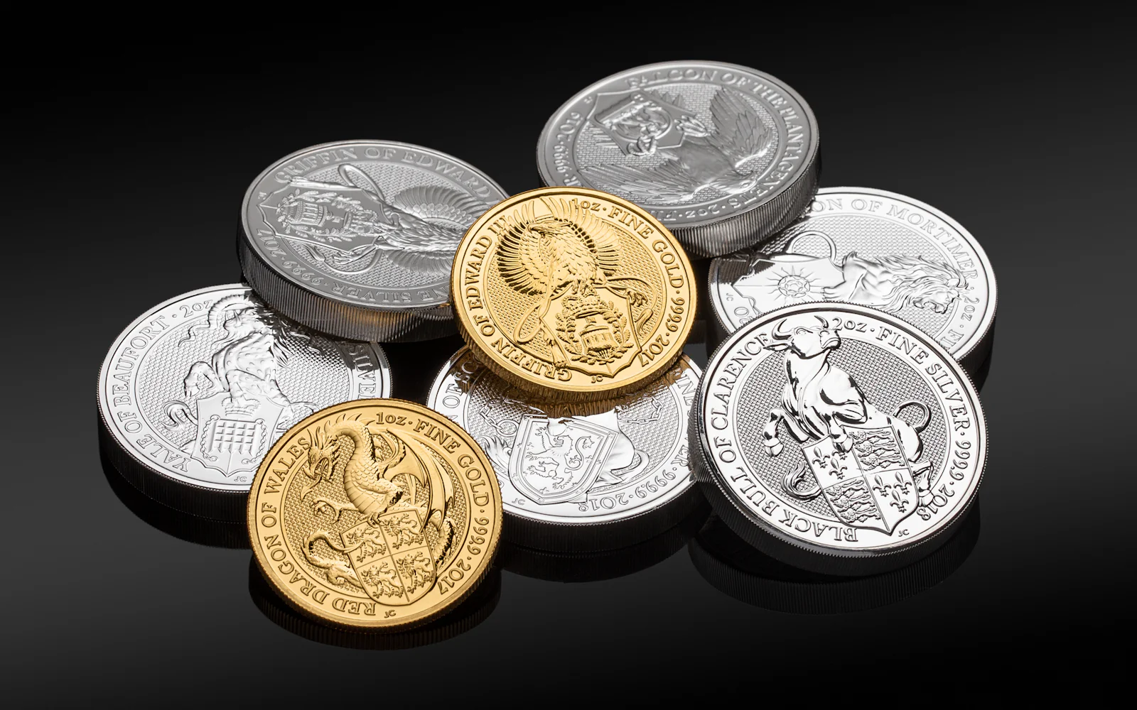 Gold and silver bullion coins together on a dark background