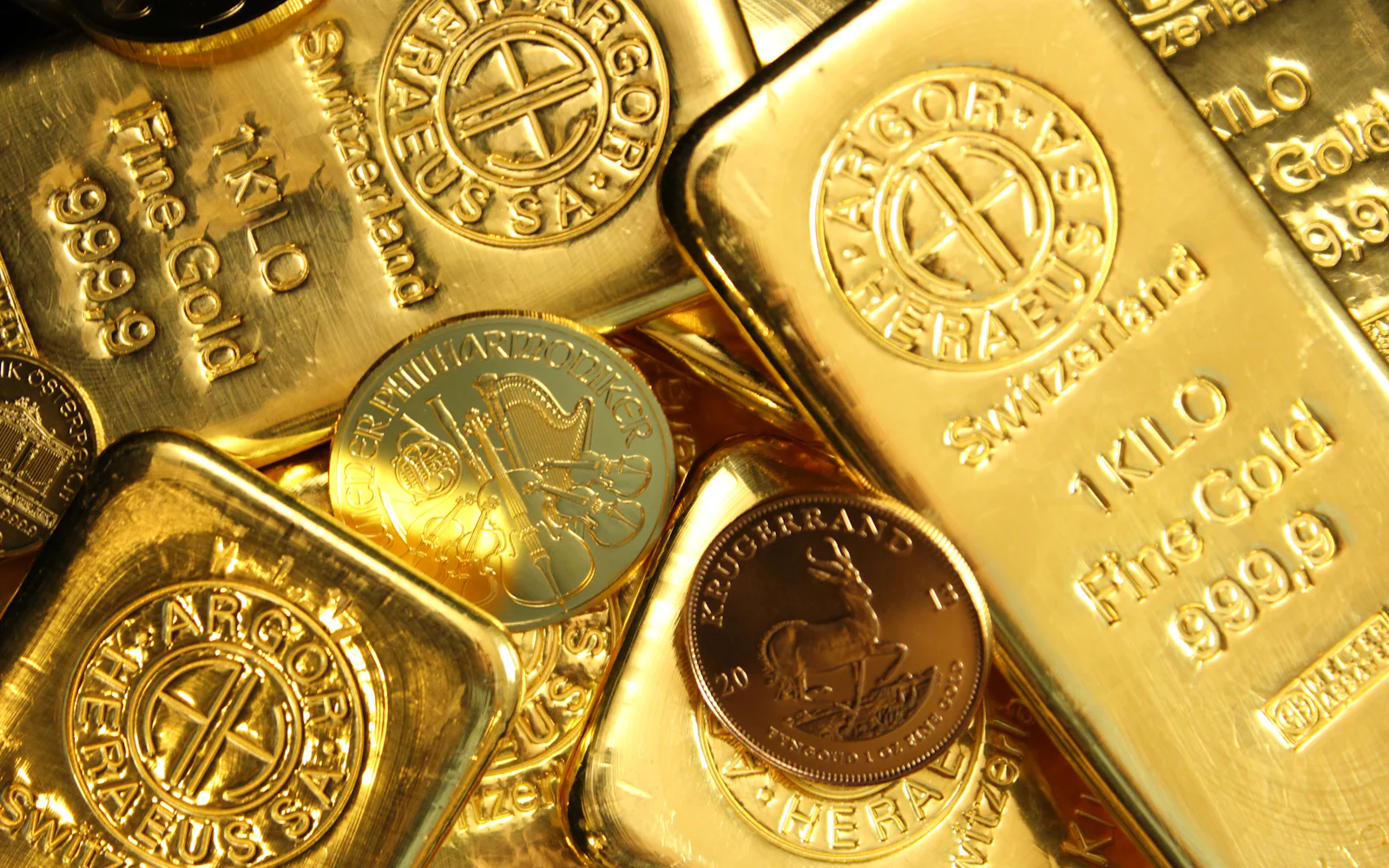 Stamped gold bars and bullion coins piled together